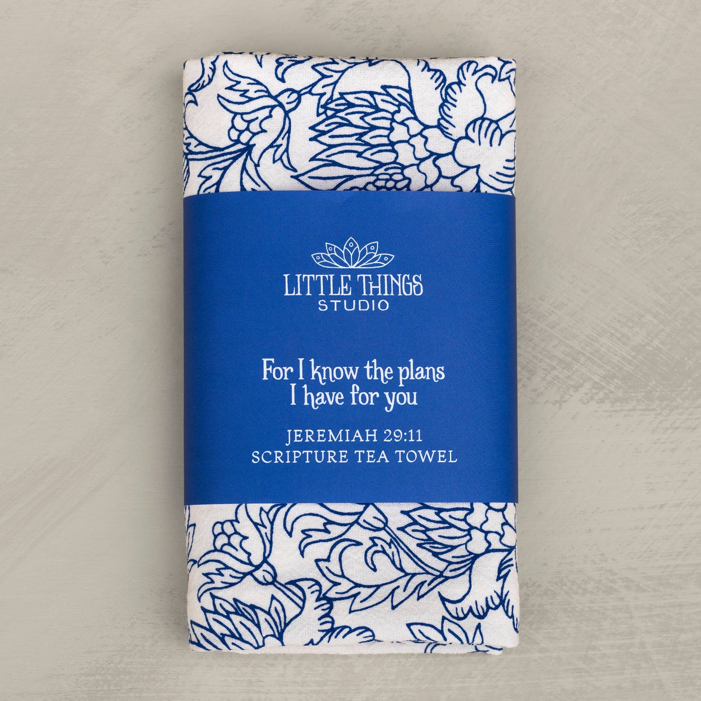 Flat lay of Jeremiah 29:11 scripture tea towel in diode blue on a wooden kitchen surface