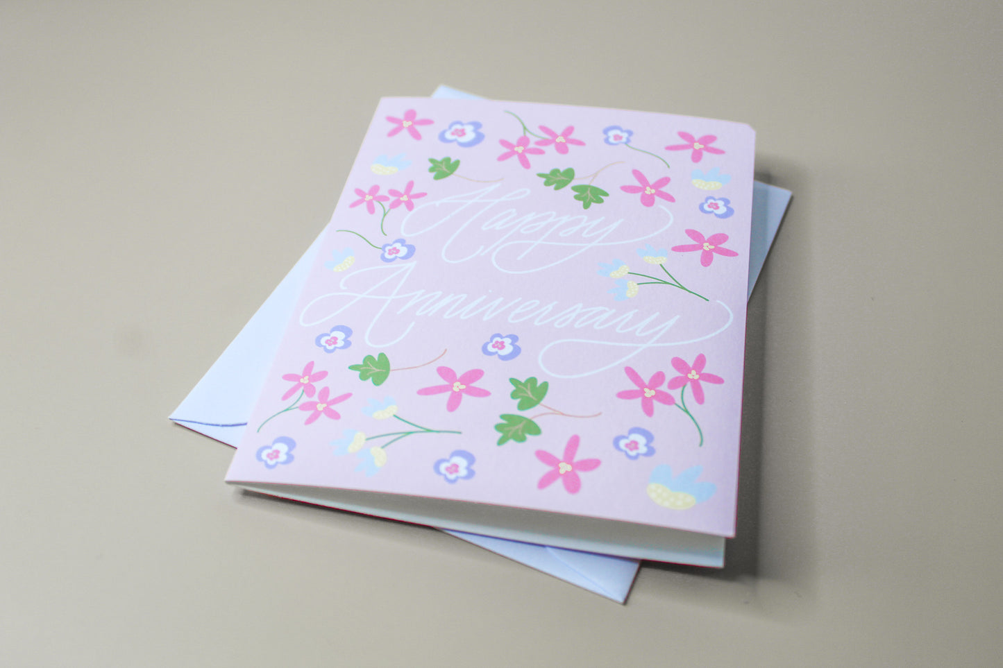 Our "Happy Anniversary" greeting card is too cute! Each card is folded to 4.25" tall by 5.5" wide, is blank inside and comes with a matching white envelope. Cards are packaged in cellophane sleeves.