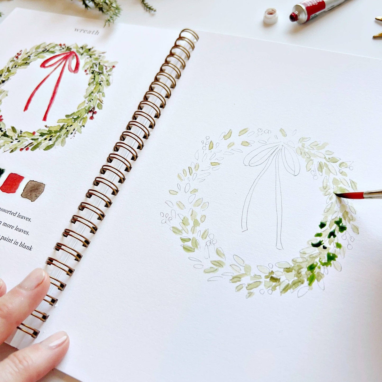 Hand-drawn wreath design in a notebook with a red pen.