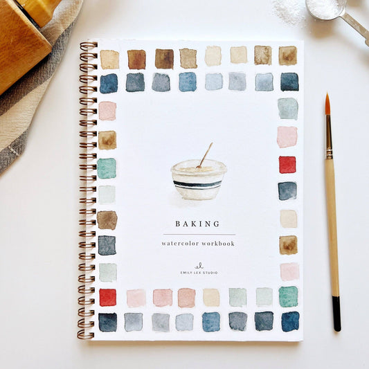 Spiral-bound watercolor workbook titled 'Baking' with color swatches on a white surface.