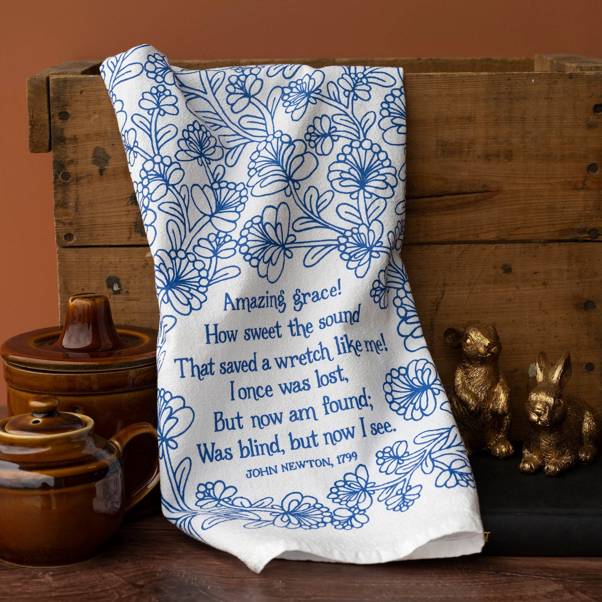 Tea towel hanging on wooden box with rustic decor in background