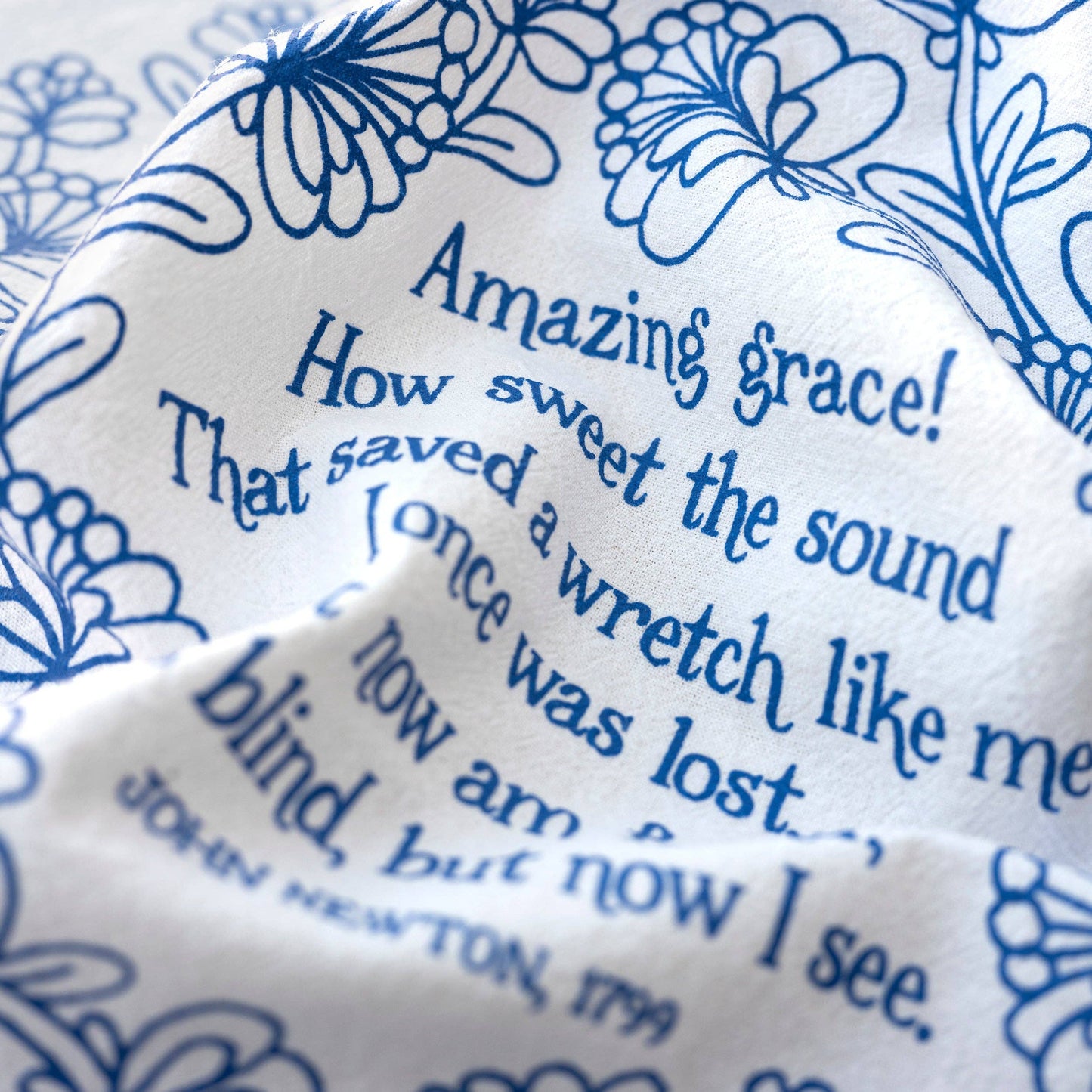 Close-up of hand-lettered Amazing Grace verse on soft white cotton fabric
