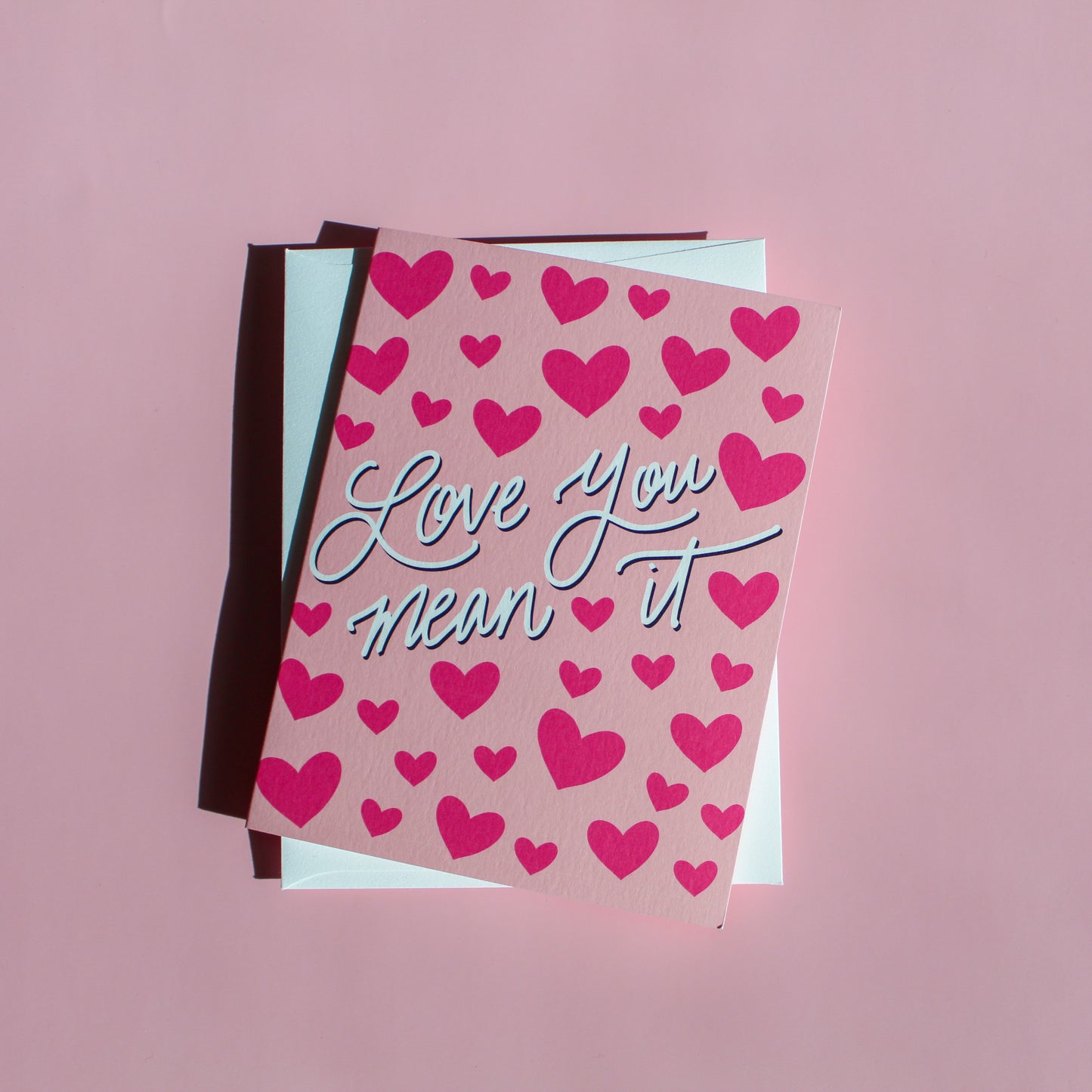 Our "Love You Mean It!" Valentine's Day card features hand drawn hearts on a pink background - it is perfect for a kid or adult! Each card is folded to 4.25" tall by 5.5" wide, is blank inside and comes with a matching white envelope. Cards are packaged in cellophane sleeves.