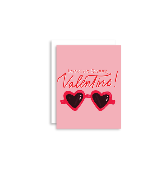 Our "Looking Sweet, Valentine!" Valentine's Day card features hand drawn heart sunglasses on a pink background - it is perfect for a kid or adult! Each card is folded to 4.25" tall by 5.5" wide, is blank inside and comes with a matching white envelope. Cards are packaged in cellophane sleeves.
